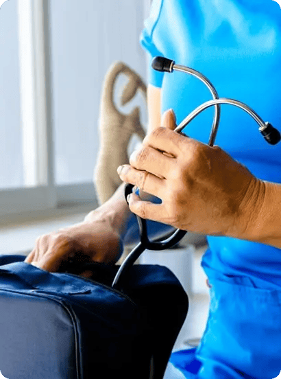 Profesional de salud del Hospital Clínica Bíblica preparando un estetoscopio en su maletín médico para una visita domiciliaria.