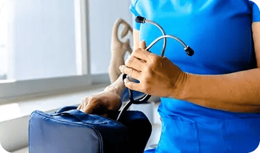 Profesional de salud del Hospital Clínica Bíblica preparando un estetoscopio en su maletín médico para una visita domiciliaria.