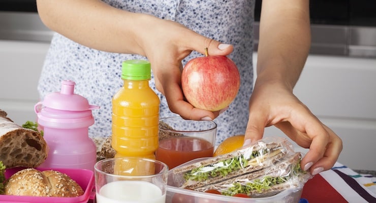 Lonchera infantil con frutas, jugo, pan y sándwich preparados para la escuela