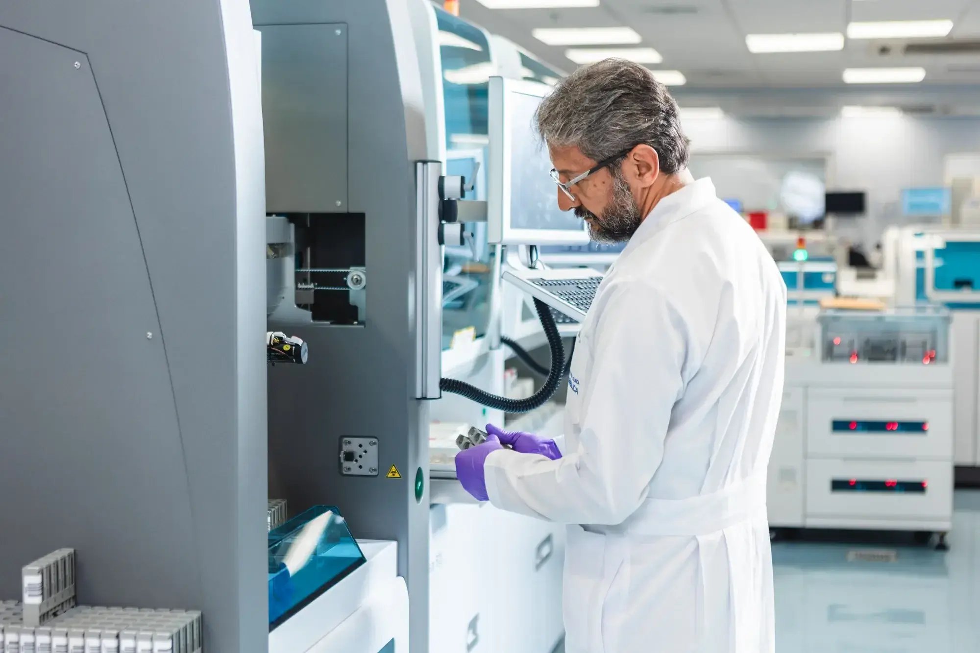 Médico con bata blanca trabajando en máquina de laboratorio clínico Médico con bata blanca trabajando en máquina de laboratorio clínico