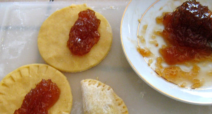 Masa redonda rellena con dulce colocada sobre una superficie de cocina