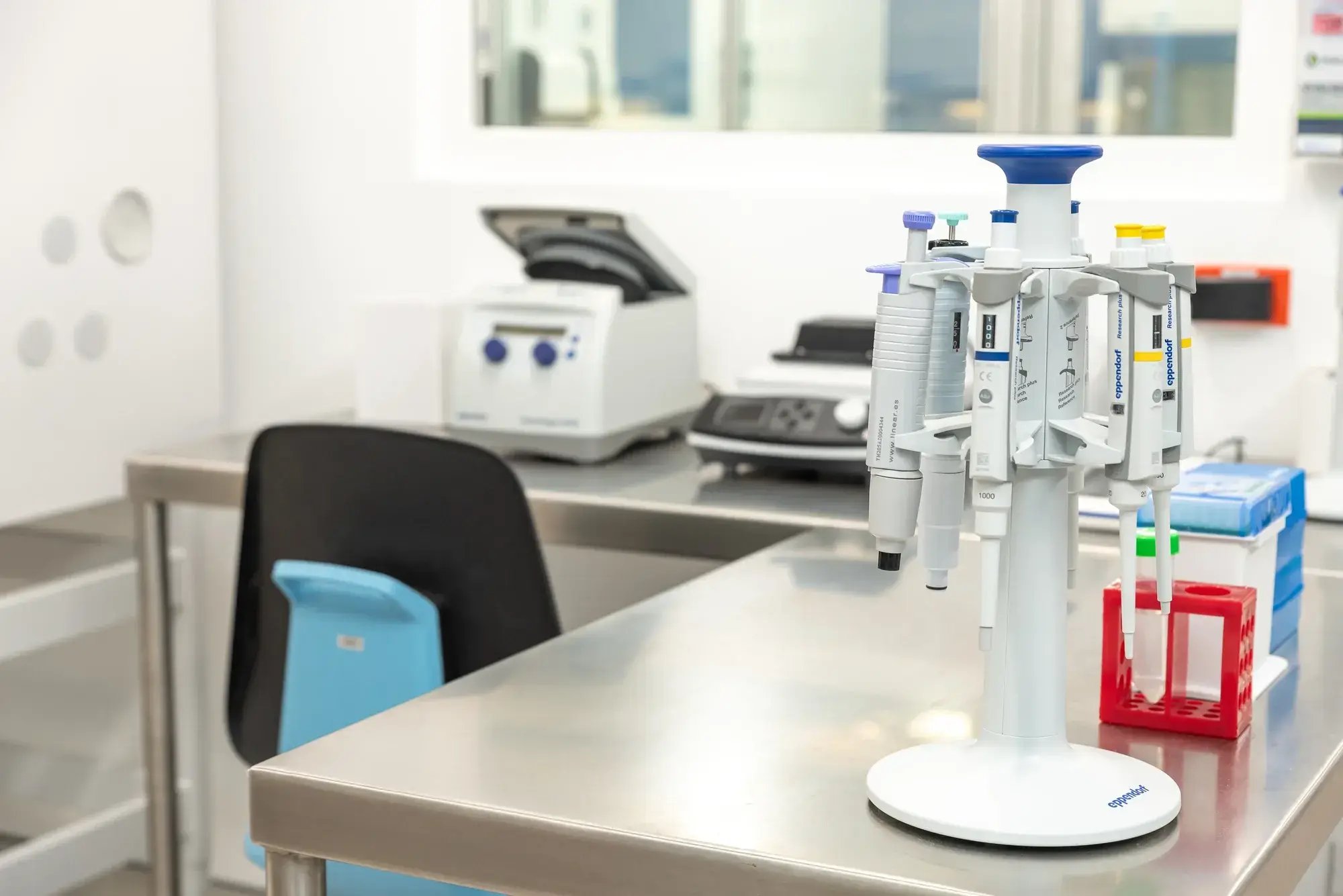 Micropipetas automáticas sobre mesa de acero en laboratorio moderno