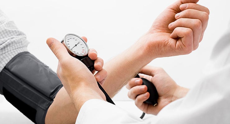 Medición de la presión arterial con tensiómetro manual en el brazo de una persona.