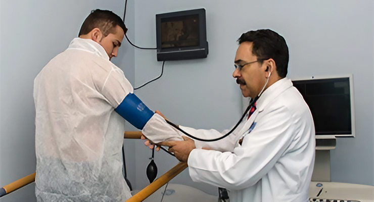 Médico midiendo la presión arterial a un paciente en consulta cardiológica