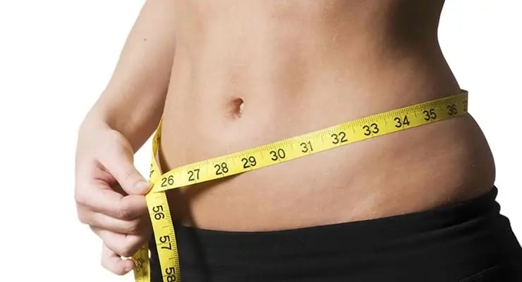 Persona midiendo el contorno de la cintura con una cinta métrica