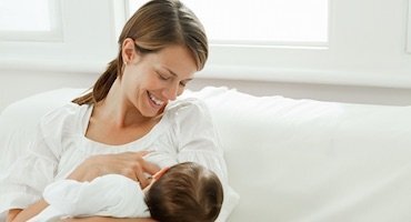 Madre amamantando a su bebé en un ambiente tranquilo y luminoso