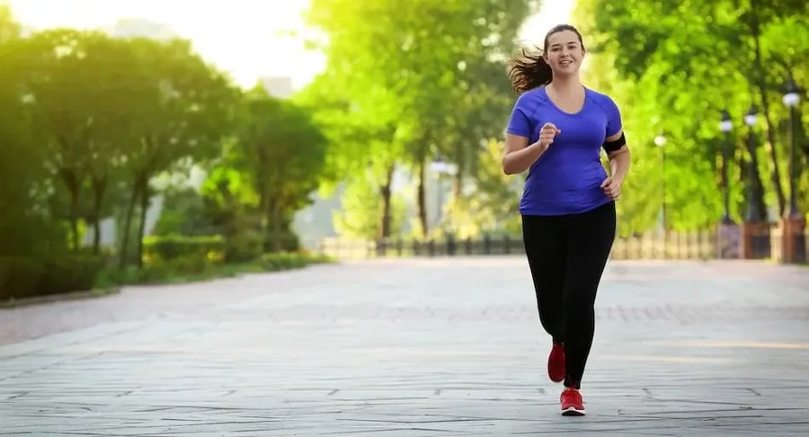 Mujer joven haciendo ejercicio al correr en un parque al aire libre
