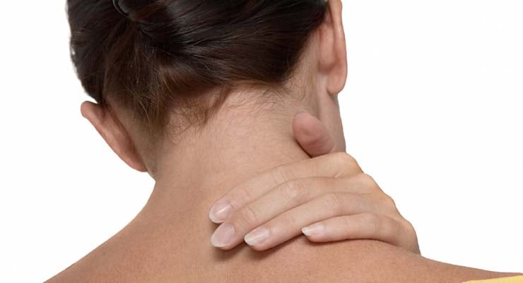 Mujer vista de espaldas tocándose la parte posterior del cuello con una mano.