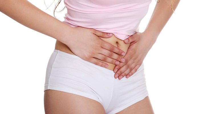 Mujer con las manos colocadas sobre la parte baja del abdomen