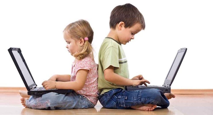 Niño y niña sentados en el suelo usando computadoras portátiles para estudiar