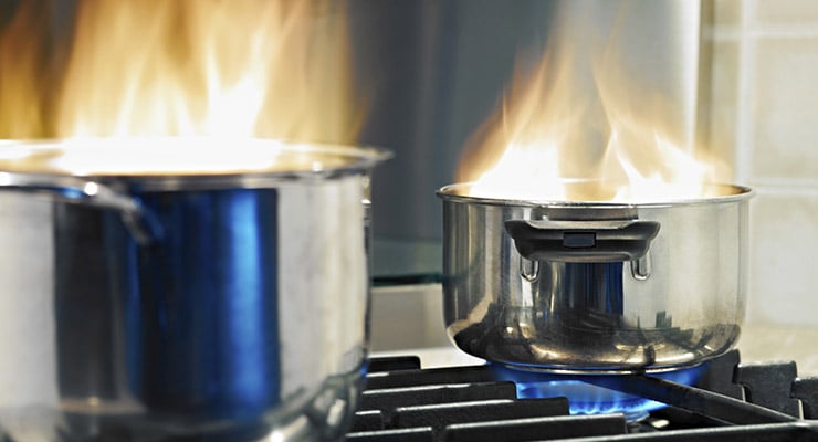 Ollas sobre una estufa de gas con fuego elevado en la cocina