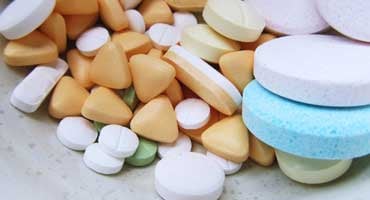 Pastillas y tabletas de diferentes colores y tamaños sobre una superficie