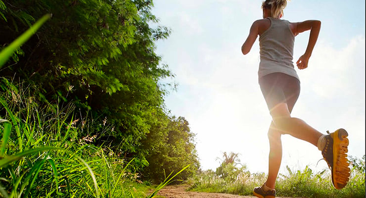 Persona corriendo al aire libre por un sendero rodeado de vegetación