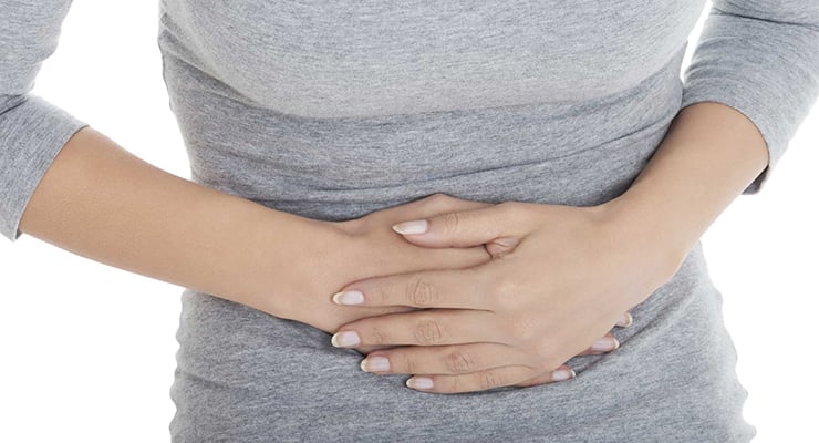 Persona con ambas manos apoyadas sobre el abdomen