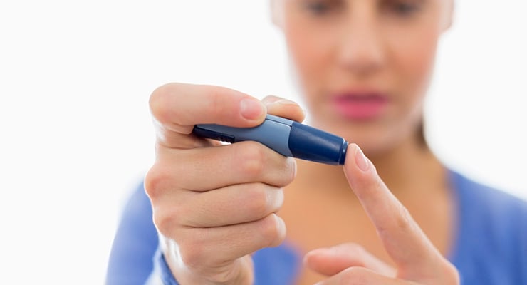 Persona utilizando un dispositivo para medir glucosa en la punta del dedo