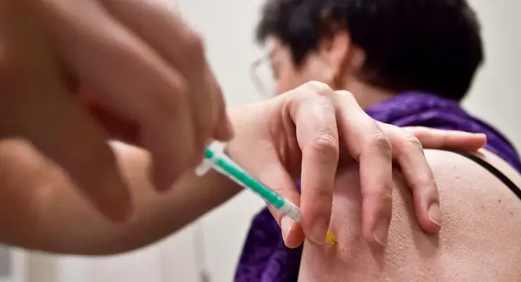 Persona recibiendo una inyección en el brazo en un entorno clínico