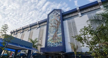 Fachada principal del Hospital Clínica Bíblica en San José, destacando su arquitectura y el icónico mural de árbol en vidrio, símbolo de su excelencia regional.