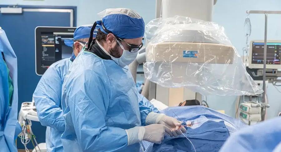 Equipo médico realizando un procedimiento quirúrgico con instrumental especializado en un quirófano.