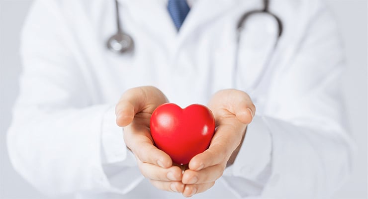 Profesional de la salud sosteniendo un corazón rojo con ambas manos