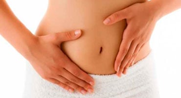 Mujer con las manos sobre el abdomen mostrando una protuberancia