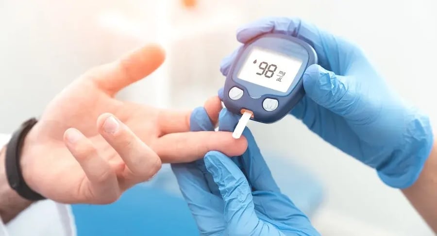 Profesional de salud midiendo nivel de glucosa en sangre con glucómetro