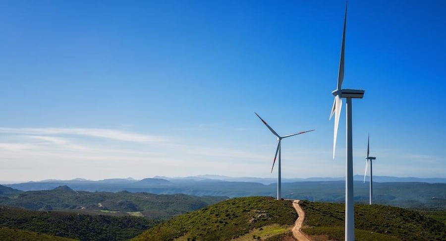 Aerogeneradores de energía eólica en un paisaje natural, asociados a iniciativas de sostenibilidad ambiental.