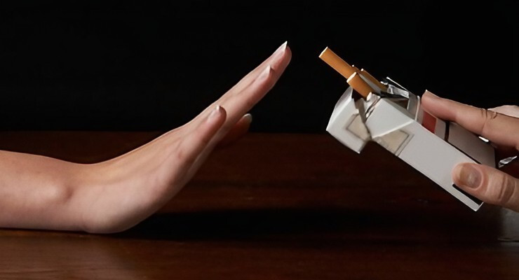 Mano levantada rechazando un cigarrillo ofrecido desde una cajetilla abierta