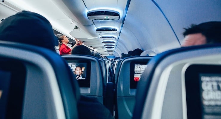 Interior de cabina de avión comercial con pasajeros sentados durante un vuelo
