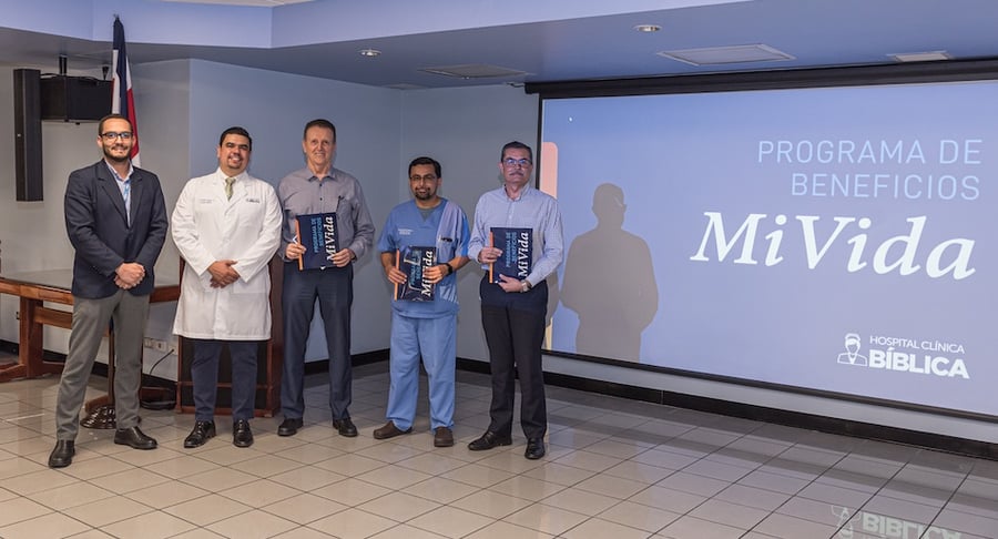 Médicos y representantes del Hospital Clínica Bíblica recibiendo reconocimiento del Programa de Beneficios Mi Vida en auditorio institucional.