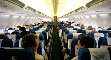 Interior de la cabina de un avión comercial con pasajeros sentados, ilustrando el entorno donde pueden ocurrir descompensaciones físicas.