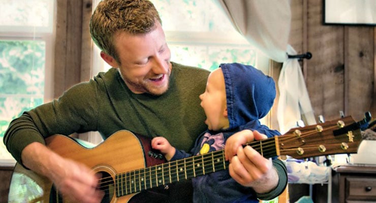 Padre tocando la guitarra y compartiendo tiempo con su bebé en casa