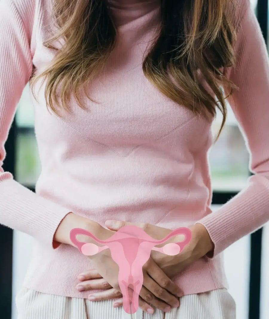 Mujer con dolor pélvico y gráfico del útero ilustrando salud ginecológica en la Clínica Bíblica.