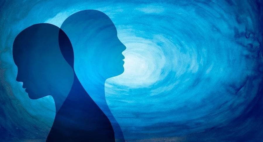 Ilustración artística en tonos azules con dos siluetas de rostros humanos superpuestos, representando los cambios de ánimo del trastorno bipolar.