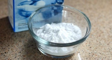 Recipiente de vidrio con sal blanca sobre encimera de cocina