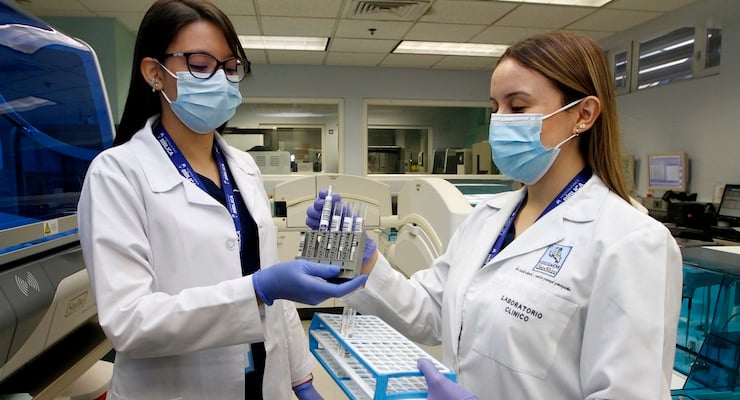 Personal de laboratorio del Hospital Clínica Bíblica manipula muestras para pruebas de antígeno mediante tecnología automatizada