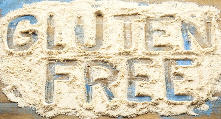 Texto “gluten free” escrito sobre harina extendida en una superficie