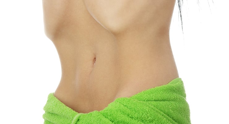Torso de una persona con abdomen visible y una toalla verde alrededor de la cintura