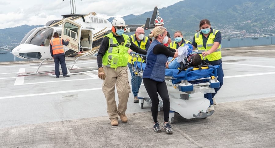 Personal médico traslada paciente en camilla desde helicóptero durante simulacro nacional de evacuación