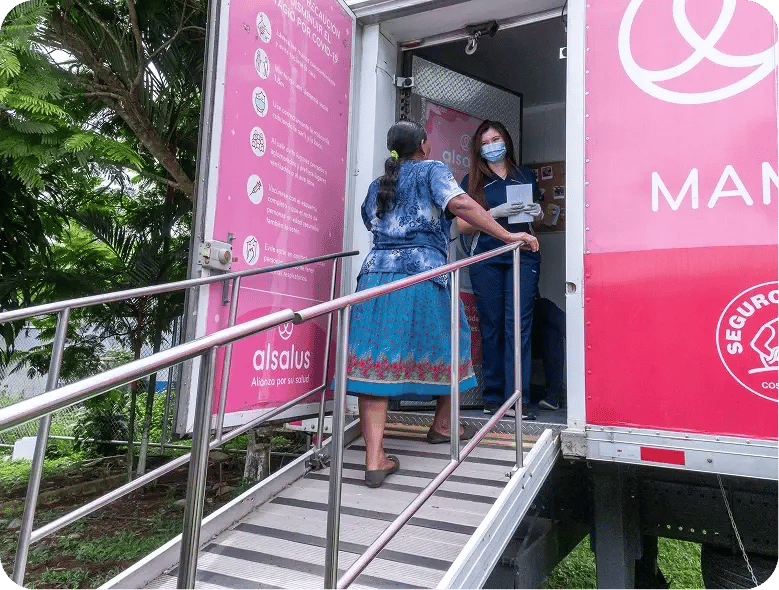 Mujer ingresando a una unidad móvil de atención médica por una rampa de acceso