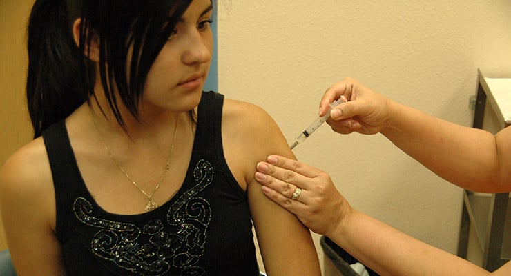 Personal de salud aplica una vacuna con jeringa en el brazo de una mujer