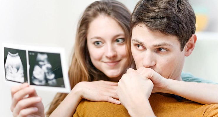 Pareja observando una imagen de ultrasonido del bebé durante el embarazo