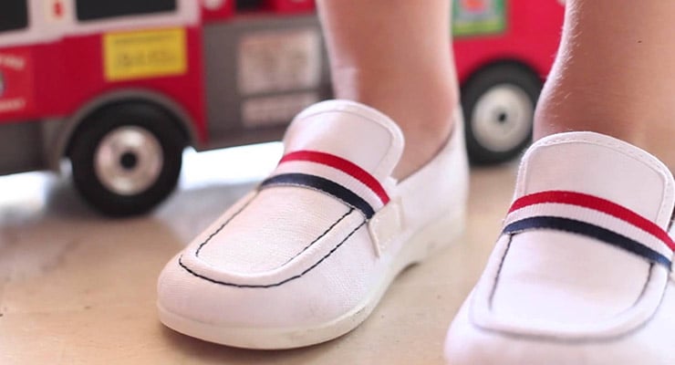Zapatos blancos de niño vistos desde el frente en un ambiente interior