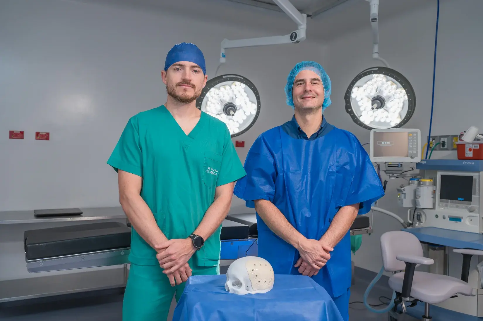 Dos cirujanos en quirófano junto a modelo anatómico de cráneo