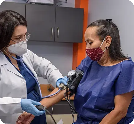 Médica toma la presión arterial a paciente en consultorio