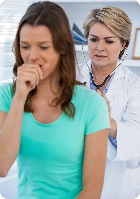 Una médica especialista ausculta con un estetoscopio la espalda de una paciente que presenta tos, durante una valoración de salud respiratoria.