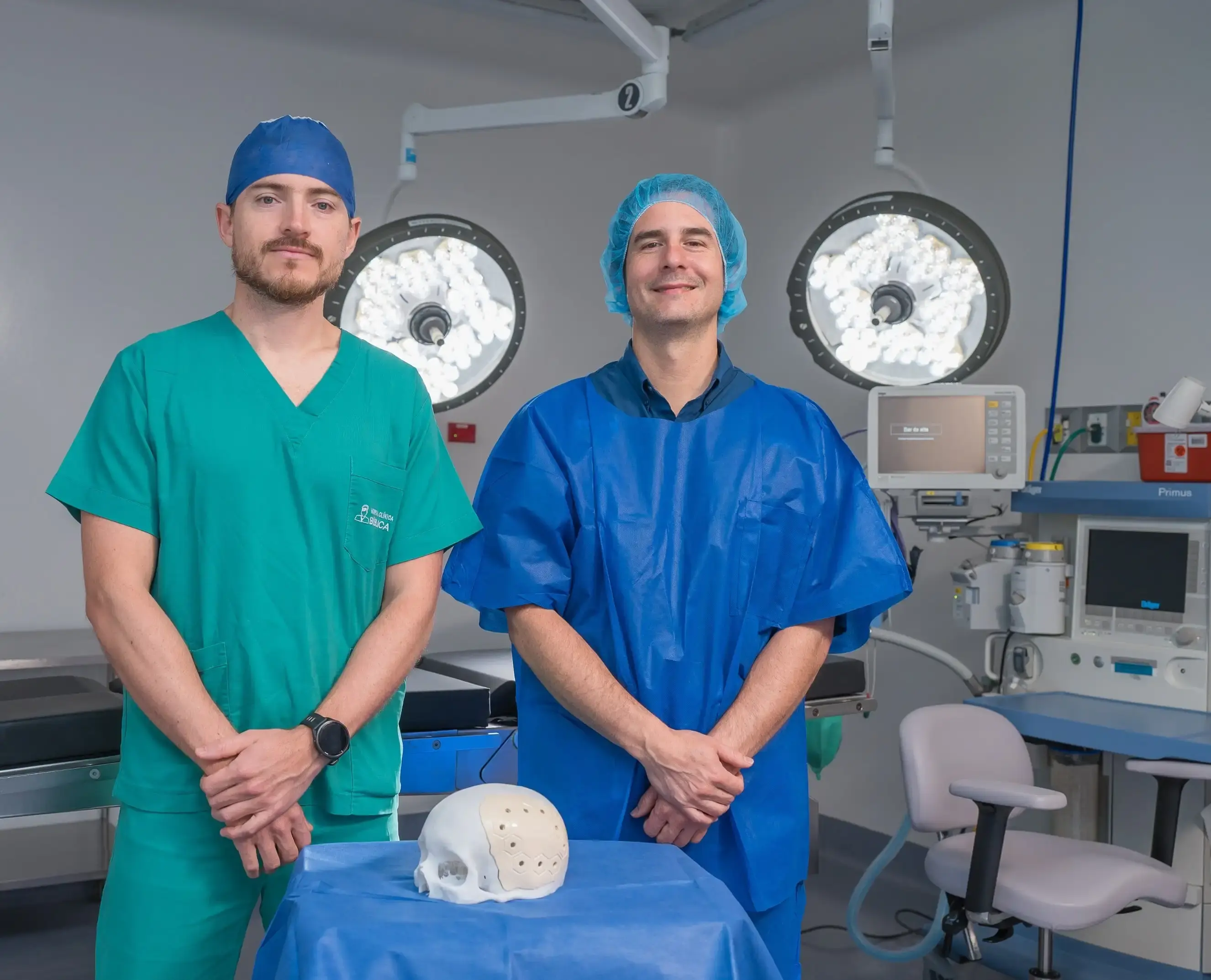 Dos médicos en sala de cirugía con equipo médico y modelo de cráneo sobre mesa