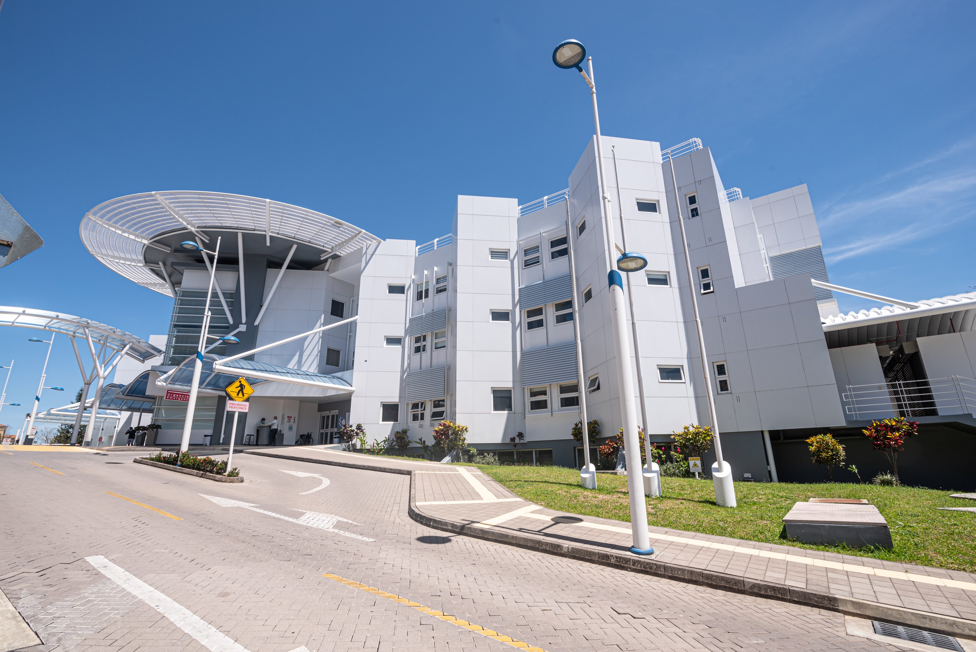 Edificio moderno de la sede Santa Ana de la Clínica Bíblica con diseño blanco y pasarelas metálicas.