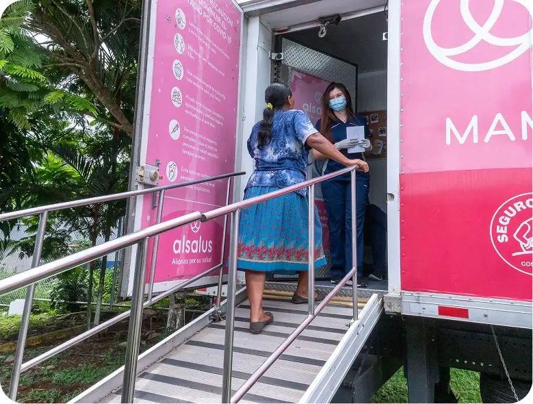 Mujer ingresando a una unidad móvil de atención médica por una rampa de acceso
